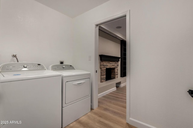 1535 E Kenwood St, Mesa, AZ 85203 - washroom featuring washer and clothes dryer, a stone fireplace, light wood-style floors, and baseboards