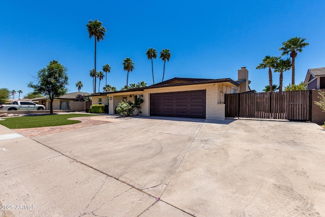 1535 E Kenwood St, Mesa, AZ 85203 - single story home featuring a garage, brick siding, driveway, a chimney, and a gate