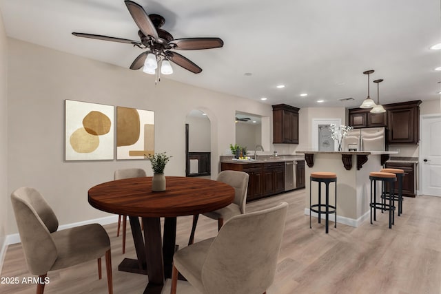 1535 E Kenwood St, Mesa, AZ 85203 - dining space featuring a ceiling fan, recessed lighting, arched walkways, baseboards, and light wood finished floors