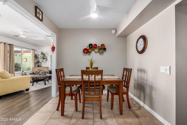 dining room with ceiling fan, baseboards, and light tile patterned floors