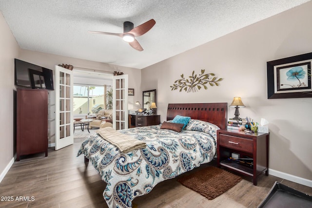 bedroom featuring french doors, ceiling fan, a textured ceiling, wood finished floors, and baseboards