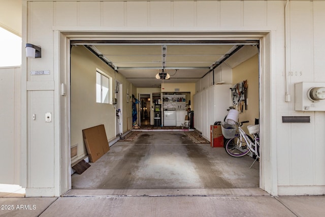 garage featuring washing machine and dryer, visible vents, and a garage door opener