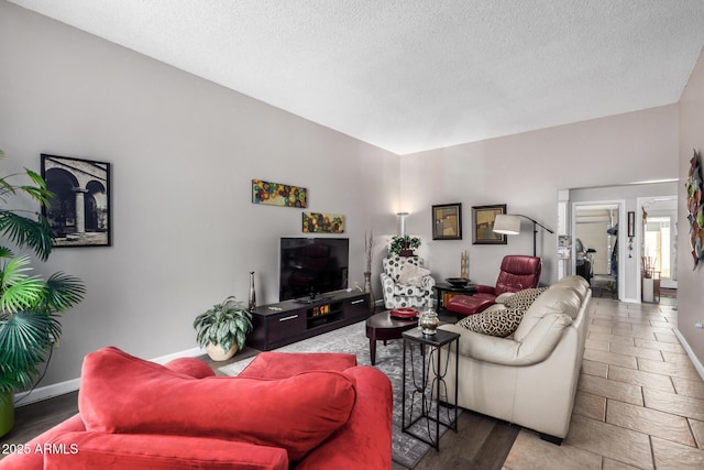 living area with baseboards and a textured ceiling