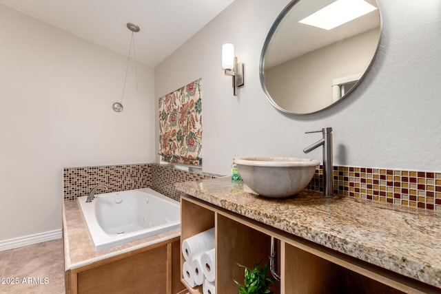 23948 W Jomax Rd, Wittmann, AZ 85361 - bathroom featuring decorative backsplash, a tub with jets, vanity, and baseboards