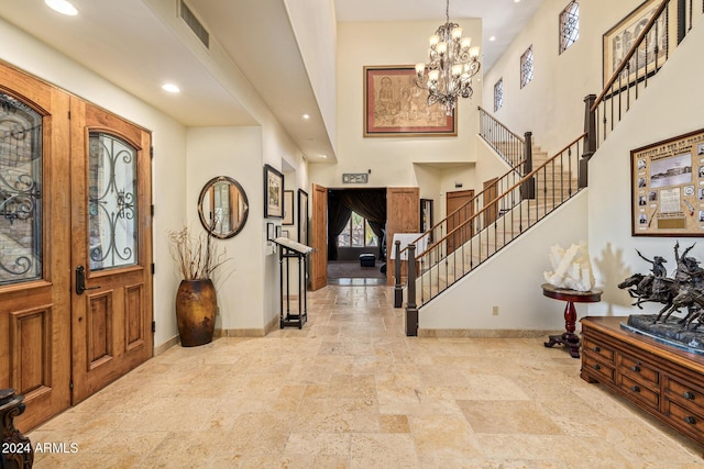 entryway featuring a notable chandelier and a towering ceiling