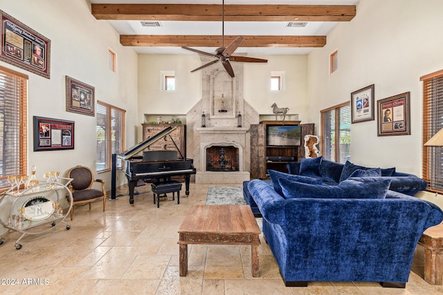 living room featuring ceiling fan, beam ceiling, and a premium fireplace