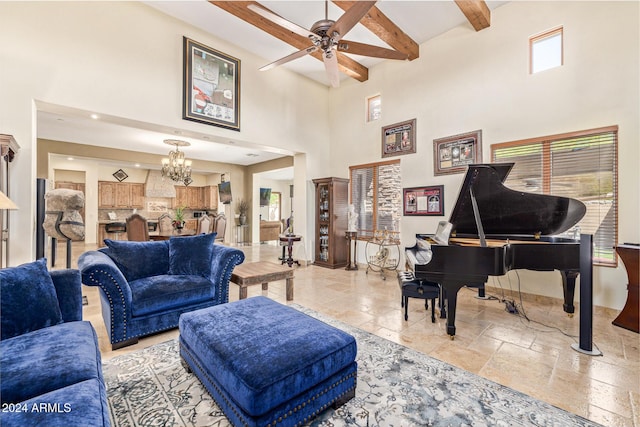 living room with beamed ceiling, a high ceiling, and ceiling fan with notable chandelier