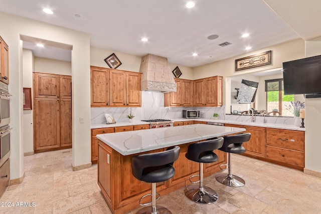 kitchen with sink, stainless steel appliances, a kitchen bar, a kitchen island, and custom exhaust hood