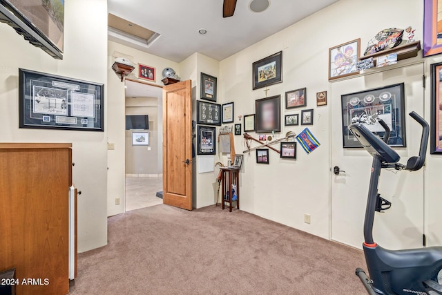 exercise area with ceiling fan and light colored carpet