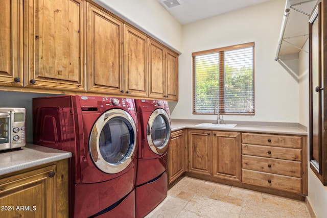 washroom with separate washer and dryer, sink, and cabinets