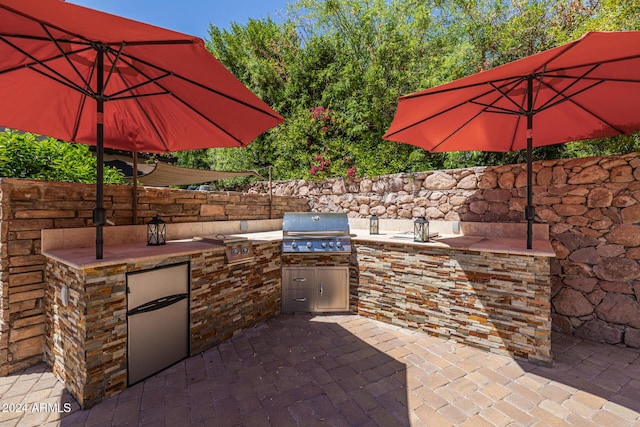 view of patio featuring an outdoor kitchen and a grill