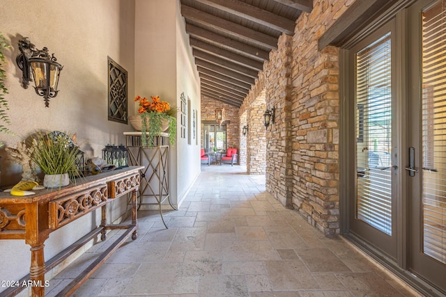 hall featuring beam ceiling, high vaulted ceiling, french doors, and wooden ceiling