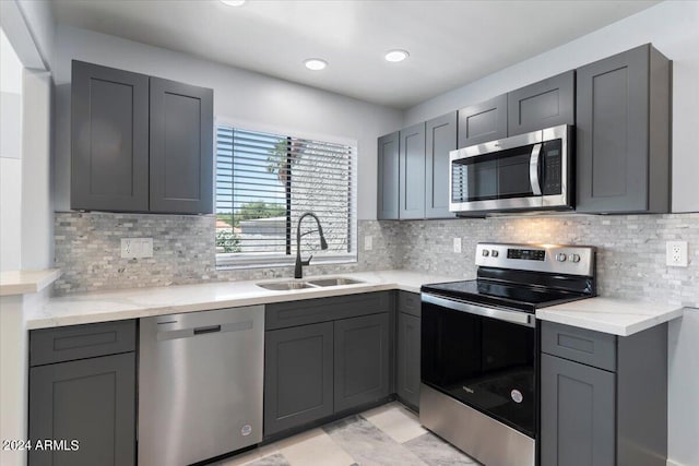 kitchen featuring sink, appliances with stainless steel finishes, gray cabinets, and tasteful backsplash