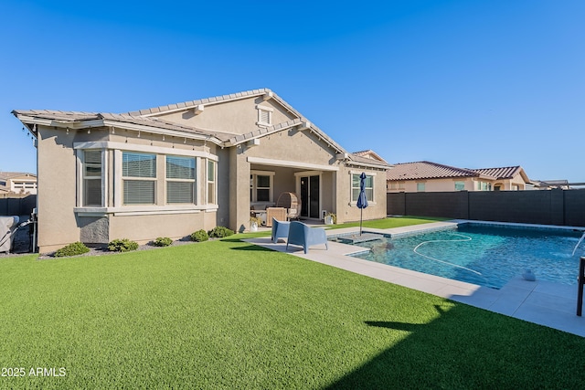 back of property featuring a lawn, pool water feature, a patio area, and a fenced in pool