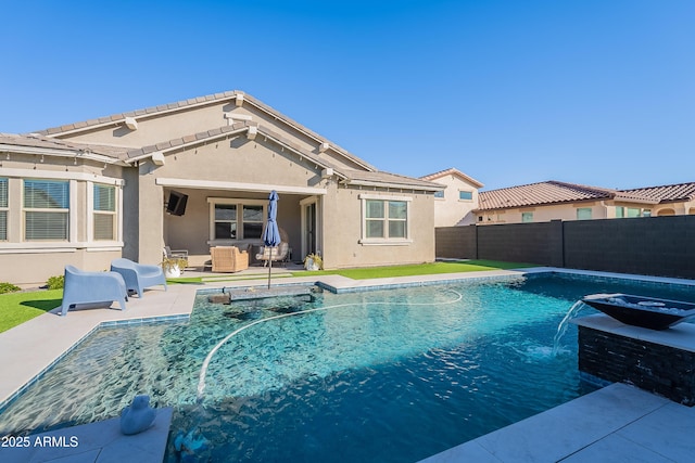 view of swimming pool with pool water feature and a patio