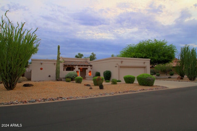 pueblo-style home featuring a garage