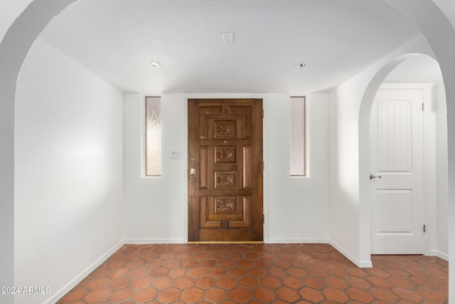 interior space with dark tile patterned flooring and a healthy amount of sunlight