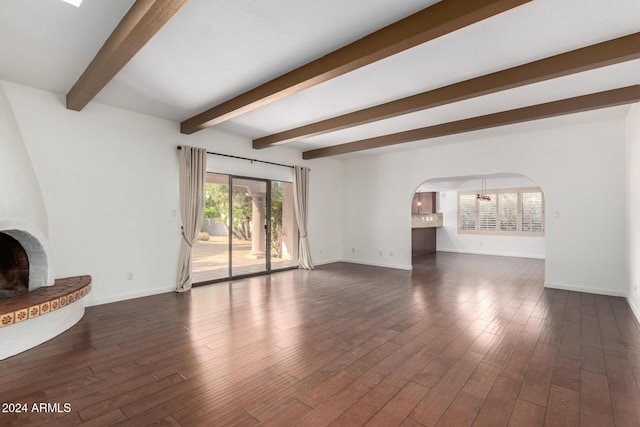 unfurnished living room with beam ceiling and dark wood-type flooring