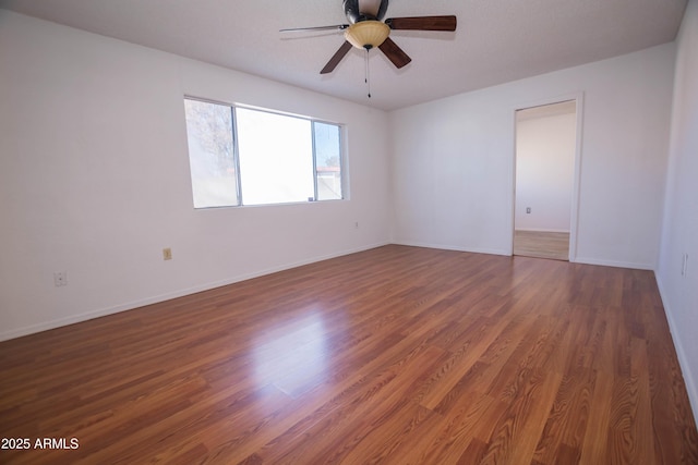 unfurnished room featuring ceiling fan and dark hardwood / wood-style flooring