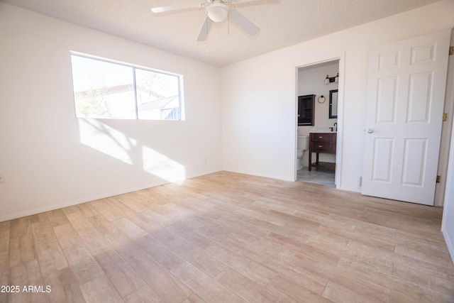 spare room featuring a textured ceiling, ceiling fan, and light hardwood / wood-style flooring