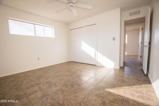 empty room featuring tile patterned floors and ceiling fan