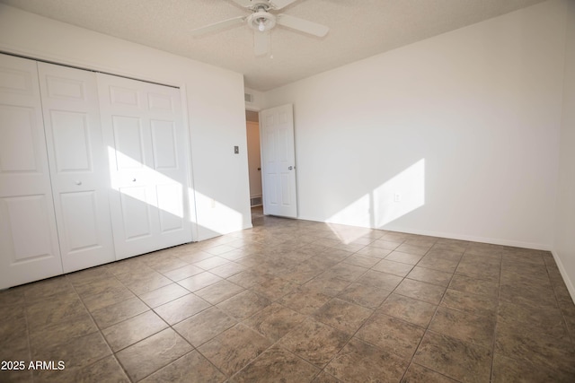 unfurnished bedroom with a textured ceiling, ceiling fan, and a closet