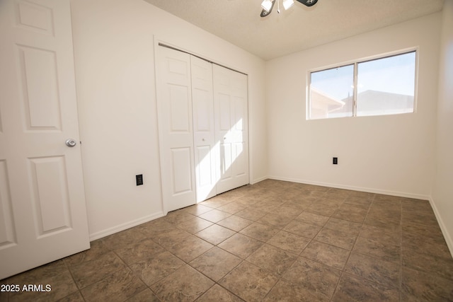 unfurnished bedroom featuring ceiling fan, a closet, and a textured ceiling