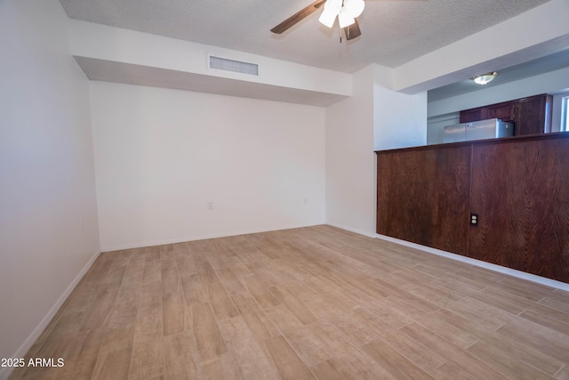 unfurnished room with a textured ceiling, ceiling fan, and light hardwood / wood-style floors