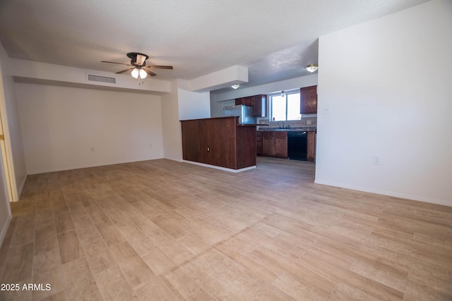 unfurnished living room with sink, a textured ceiling, ceiling fan, and light hardwood / wood-style floors