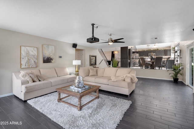 living area with baseboards, ceiling fan, and wood tiled floor