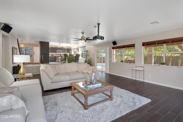 living room featuring dark wood-style floors, visible vents, ceiling fan, and baseboards