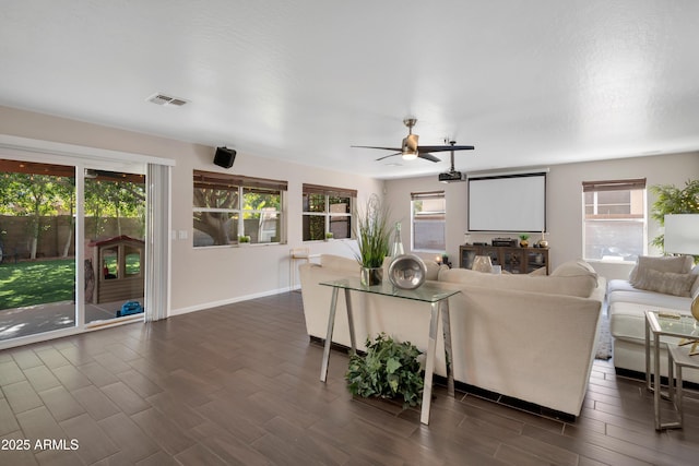 unfurnished living room featuring baseboards, visible vents, dark wood finished floors, and a ceiling fan