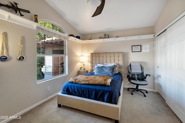 carpeted bedroom featuring lofted ceiling, a closet, a ceiling fan, and baseboards