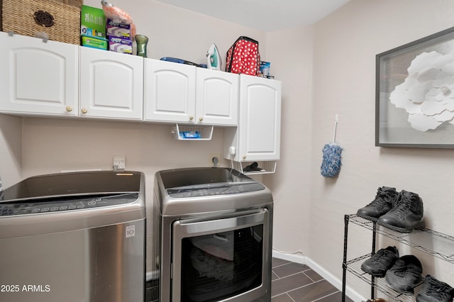 clothes washing area featuring cabinet space, baseboards, and washing machine and clothes dryer