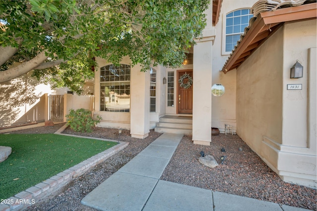 doorway to property featuring a gate and stucco siding