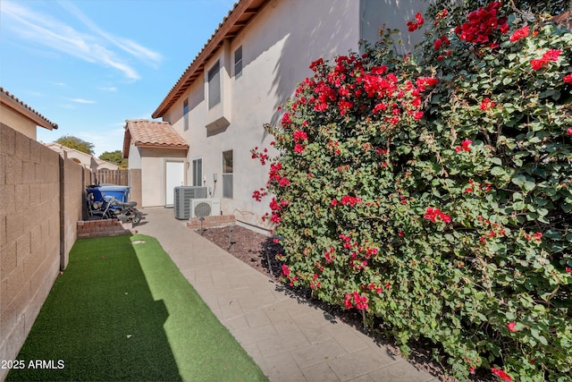 back of property with a tile roof, a fenced backyard, and stucco siding