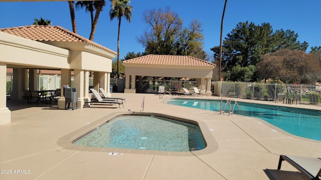 community pool featuring fence, a patio, and a gazebo