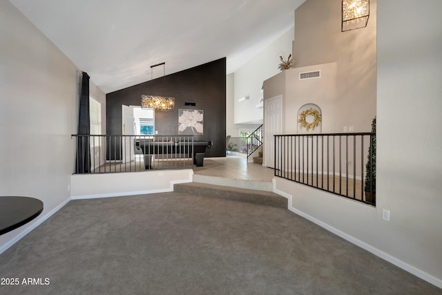 corridor featuring high vaulted ceiling, a notable chandelier, visible vents, baseboards, and carpet