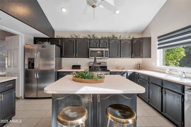 kitchen with light countertops, stainless steel appliances, a sink, and light tile patterned flooring