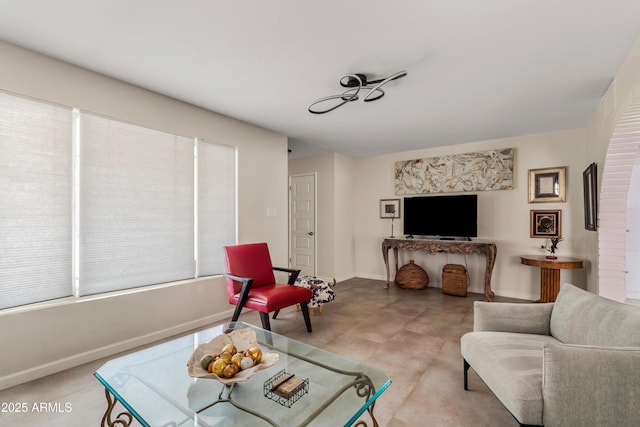 sitting room featuring a healthy amount of sunlight and baseboards