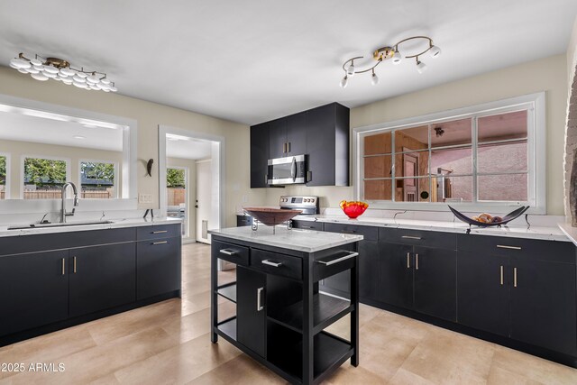 kitchen with a sink, light stone countertops, stainless steel microwave, and dark cabinets