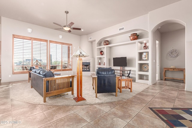 living room with ceiling fan, light tile patterned floors, and built in features