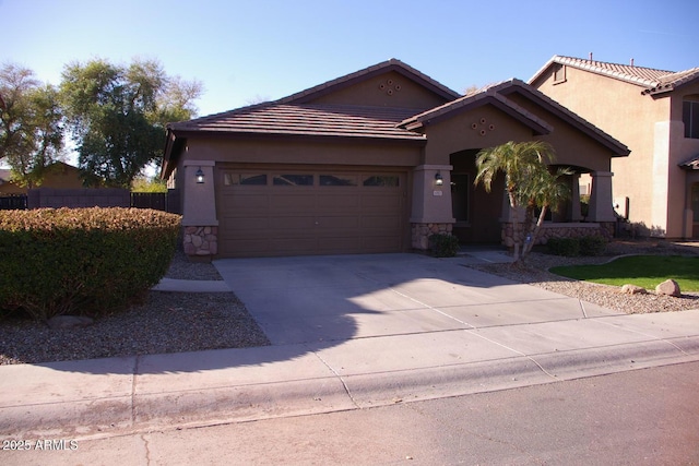 view of front of house featuring an attached garage, stone siding, concrete driveway, and stucco siding