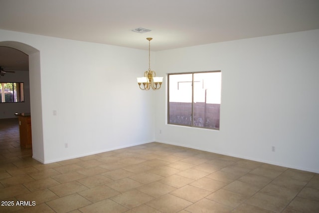 empty room featuring ceiling fan with notable chandelier