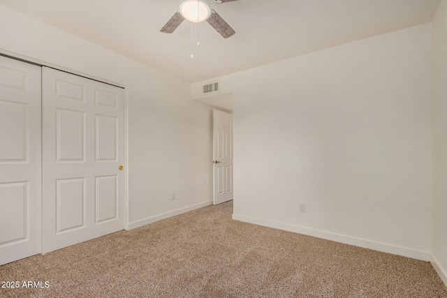unfurnished bedroom featuring a ceiling fan, visible vents, light colored carpet, baseboards, and a closet