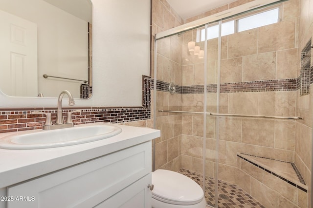 full bathroom featuring vanity, toilet, tile walls, a shower stall, and backsplash