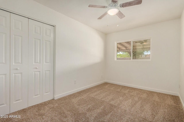 unfurnished bedroom featuring baseboards, a ceiling fan, carpet, and a closet