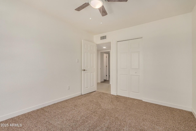 unfurnished bedroom featuring carpet floors, visible vents, a closet, baseboards, and ceiling fan