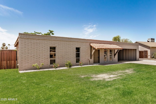 view of front of property featuring concrete driveway, fence, a front yard, and a garage