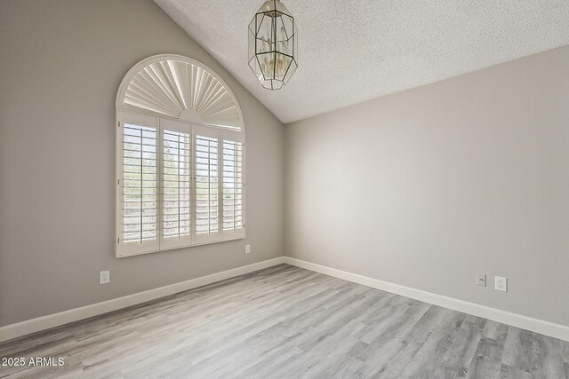 4627 E Mcneil St, Phoenix, AZ 85044 - spare room with a chandelier, lofted ceiling, a textured ceiling, wood finished floors, and baseboards